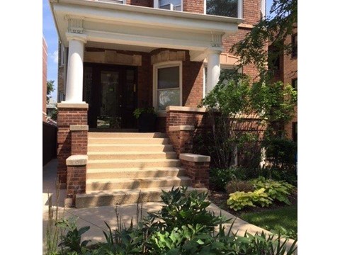 a brick house with steps and a front porch