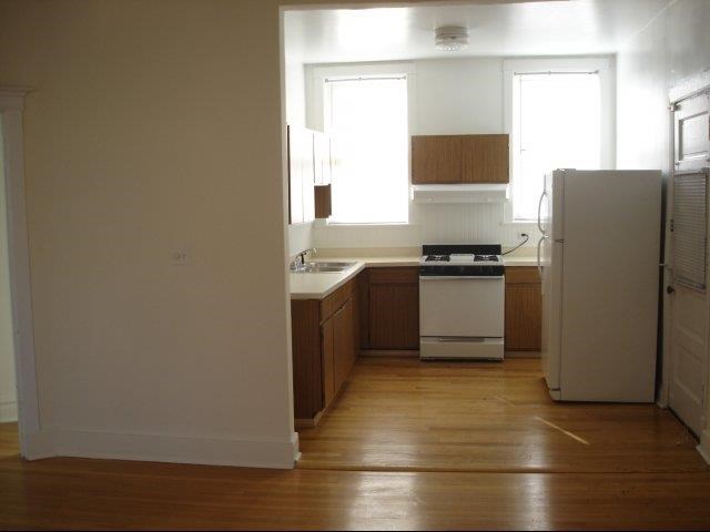 an empty kitchen with a stove and a refrigerator