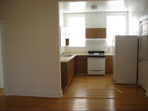 an empty kitchen with a stove and a refrigerator