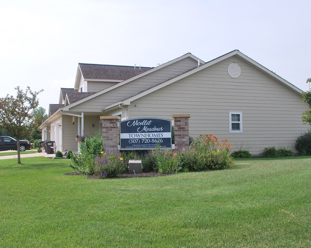 a house with a sign in front of a lawn