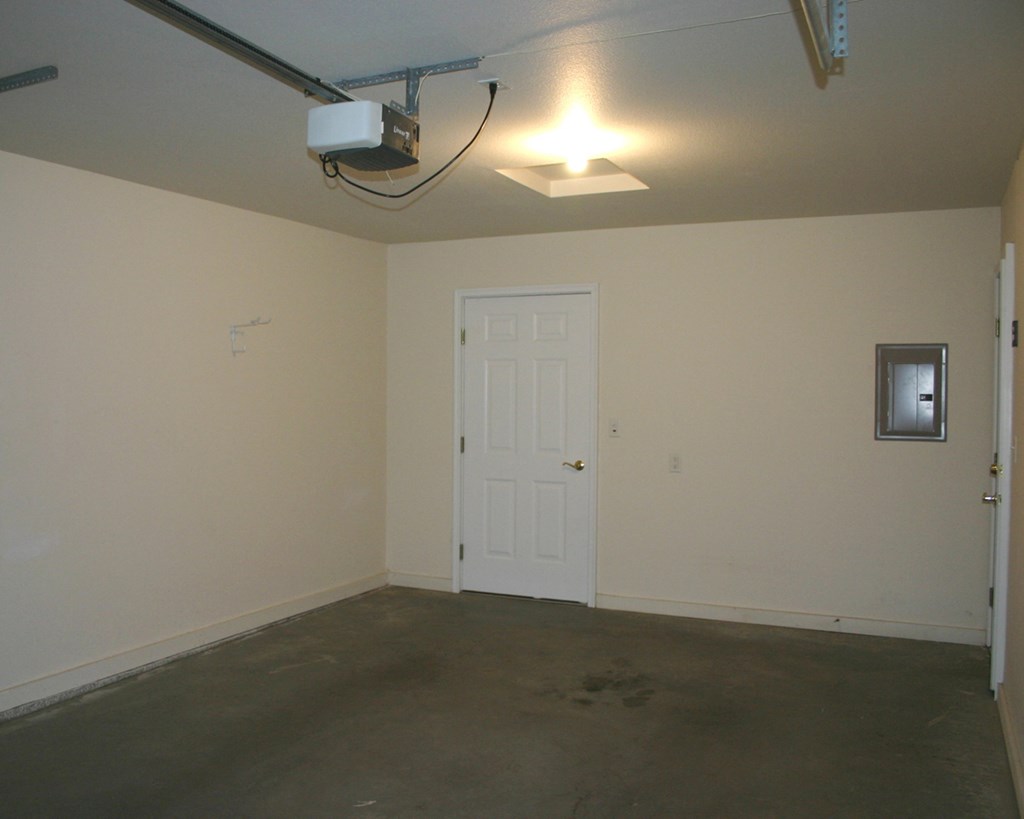 an empty room with a white door and a ceiling fan