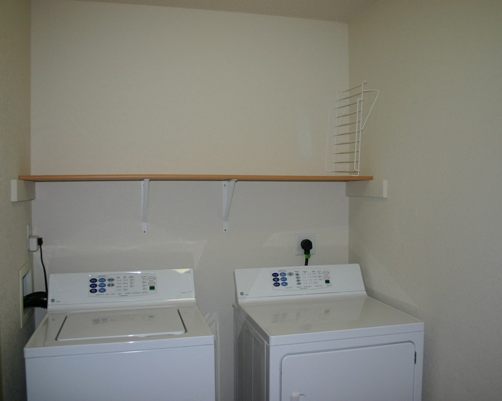 two washers and a dryer in a laundry room