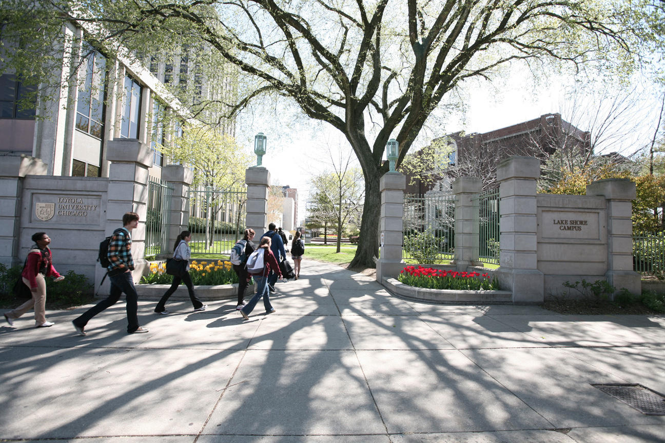 a group of people walking in front of a university building