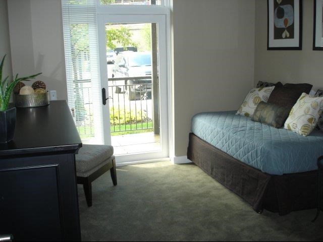 a bedroom with a bed and a door to a patio
