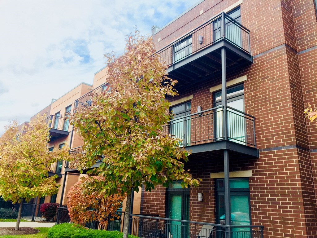 a brick apartment building with green doors and balconies