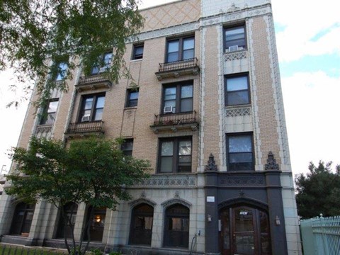 a tall brick building with a tree in front of it