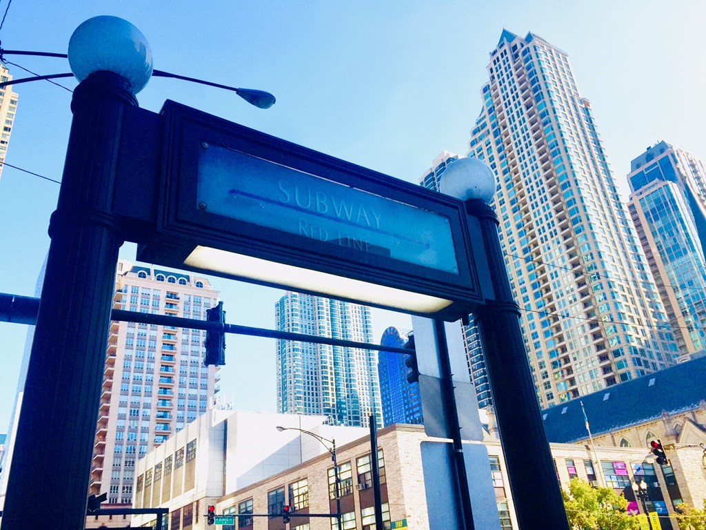 a subway sign with skyscrapers in the background