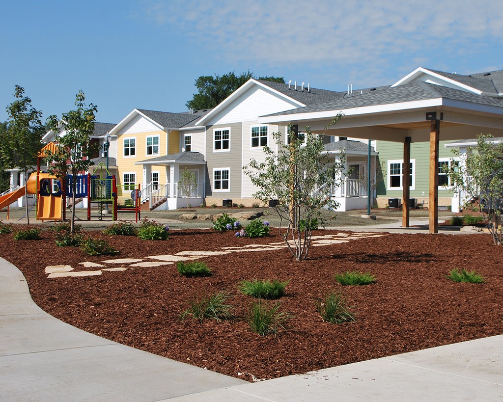 a playground in front of a house with a pavilion