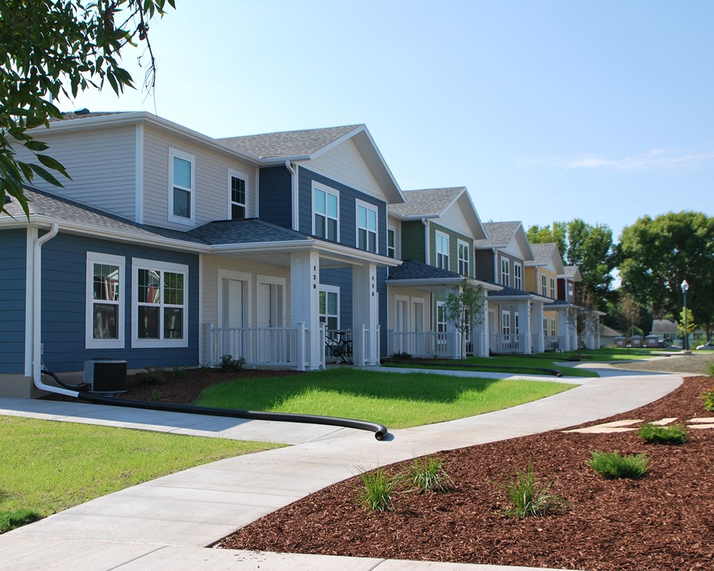 a row of houses with a sidewalk in front of them