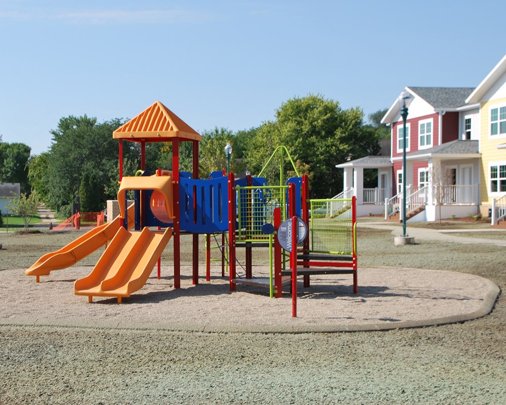 a playground with a swing set and a slide in a park
