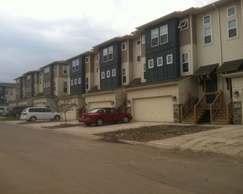 an apartment building on a street with cars parked in front