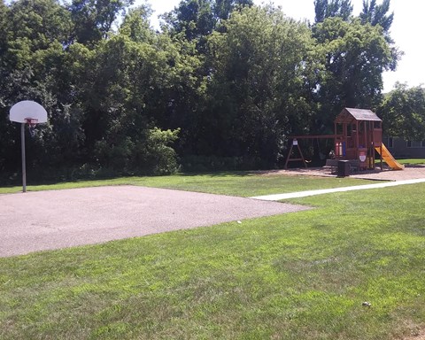 a playground with a swing set and a basketball court
