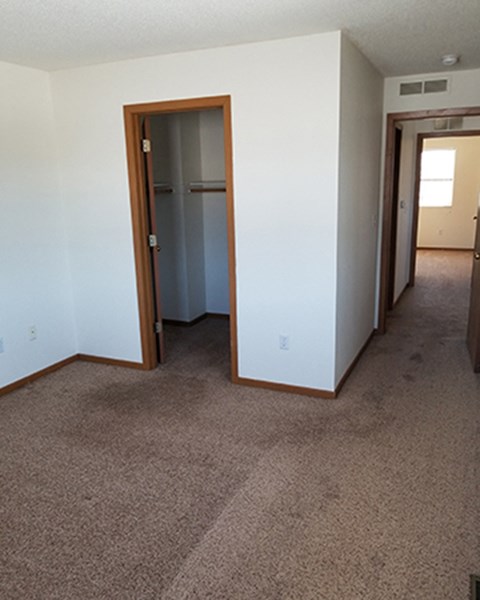 the view from the living room into the bedroom and the hallway to the bathroom