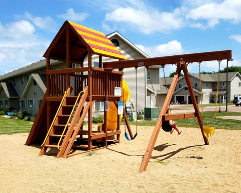 a child playing on a swing set in a playground