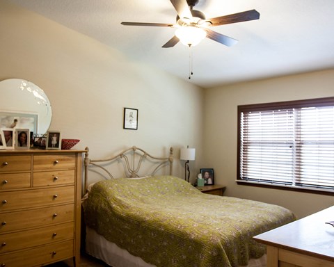 a bedroom with a bed and a ceiling fan