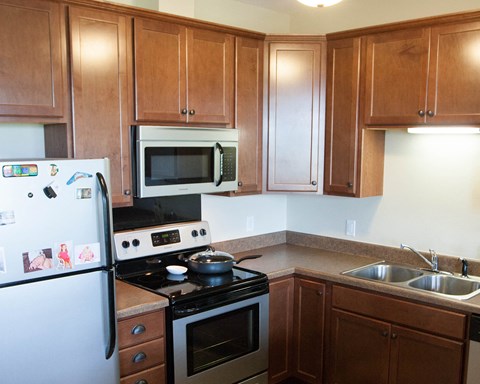 a kitchen with a stove and a refrigerator and a sink