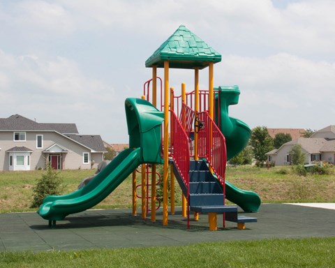 a colorful playground with a slide in a park