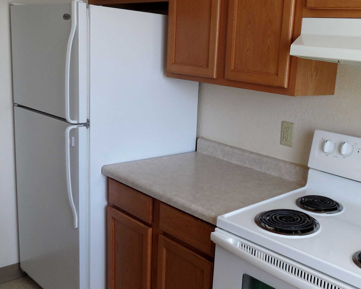 a kitchen with white appliances and wooden cabinets and a white refrigerator