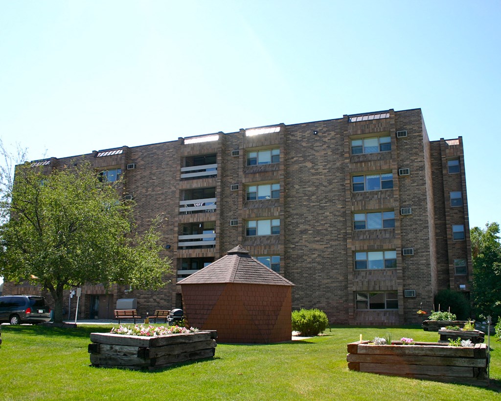 a large brick building with a garden in front of it