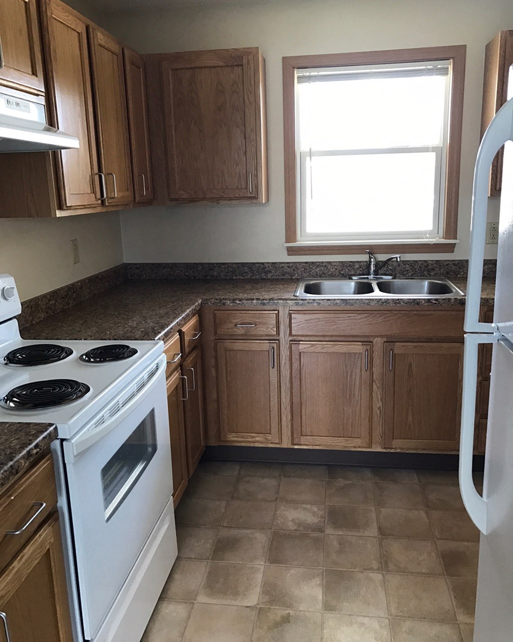 a kitchen with white appliances and wooden cabinets