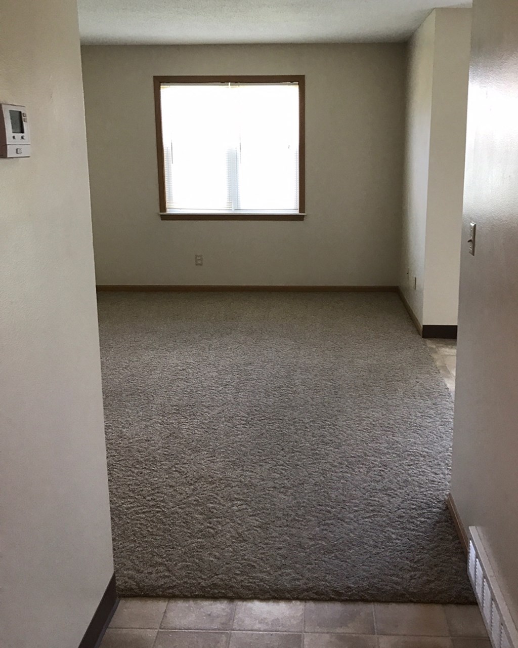 a room with a carpeted floor and a window