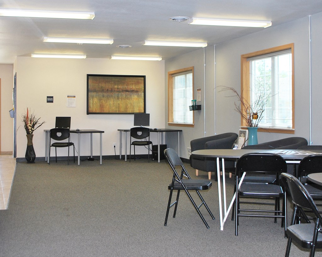 a conference room with tables and chairs and a projector screen