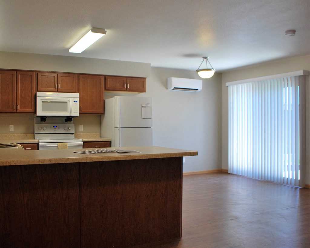 an empty kitchen with wooden cabinets and a counter top