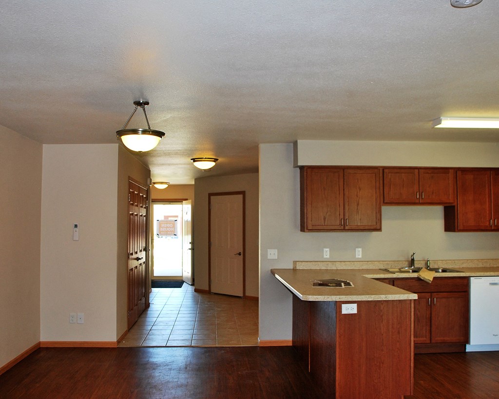 an empty kitchen with wooden cabinets and a counter top