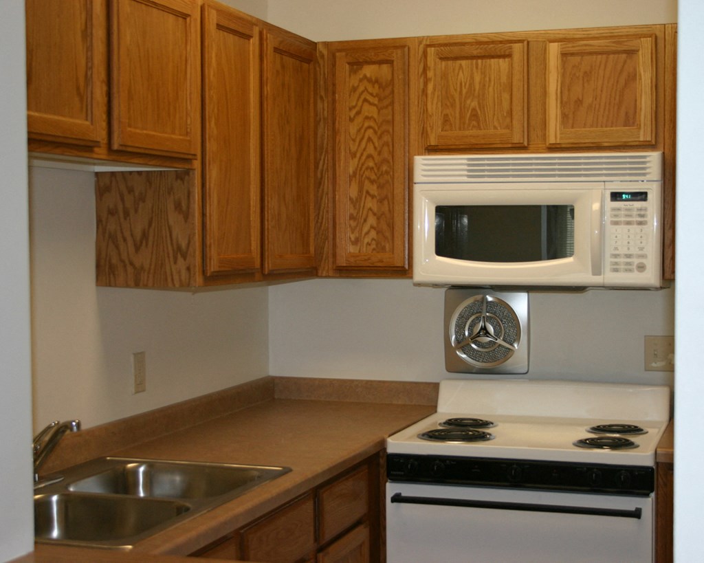 a small kitchen with a stove microwave and sink