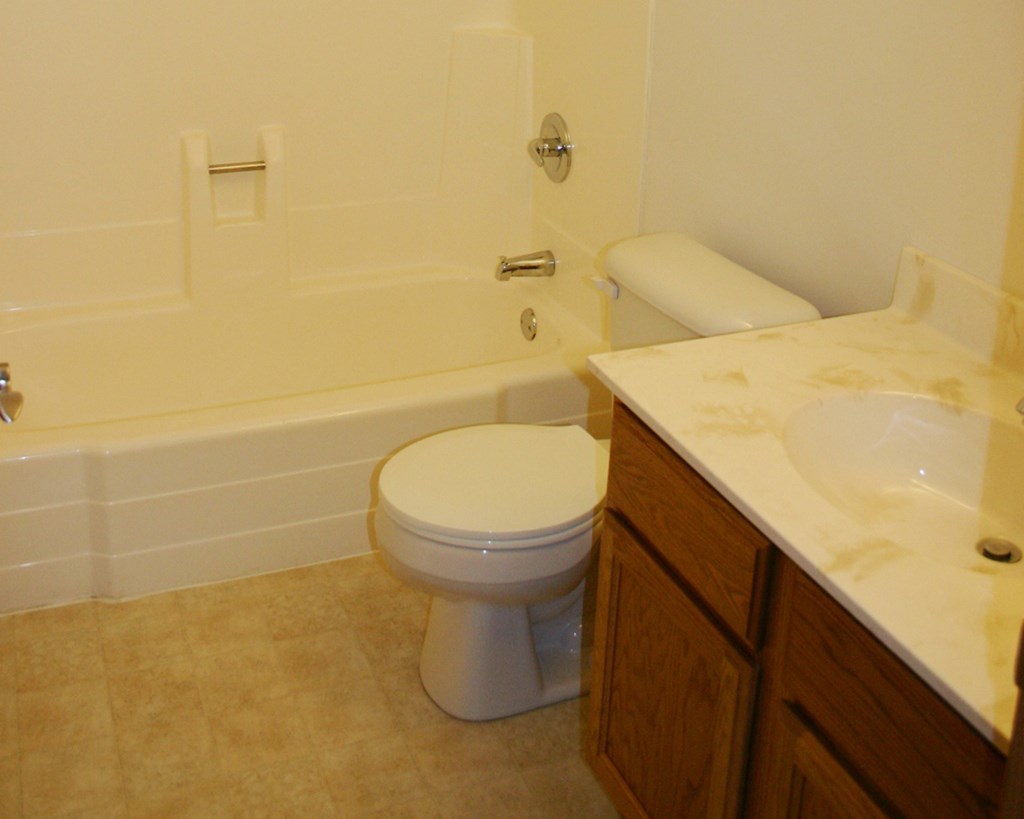 a bathroom with a toilet and a tub and a sink