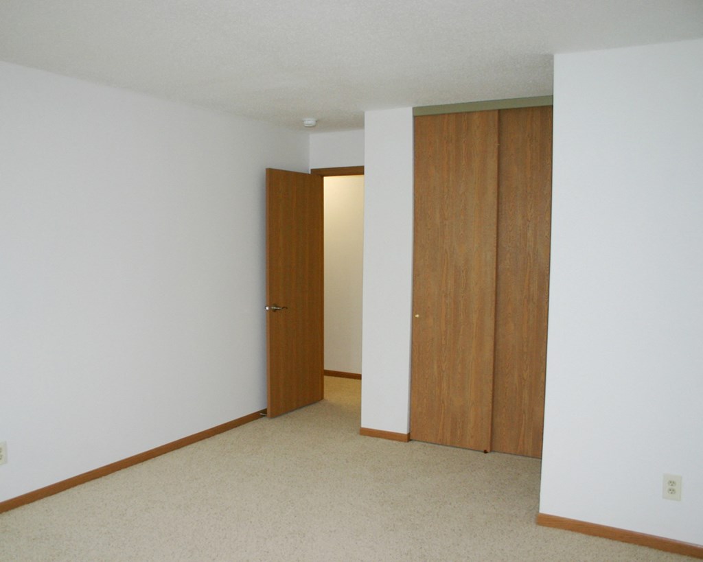 an empty room with two doors and a white wall