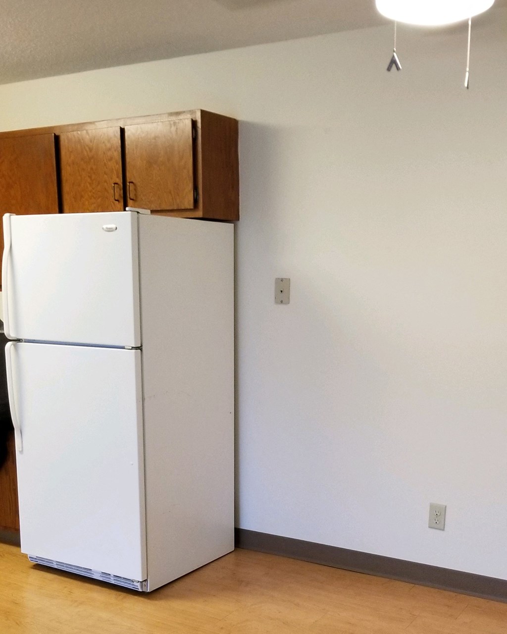 a kitchen with a refrigerator and a cabinet on top of it