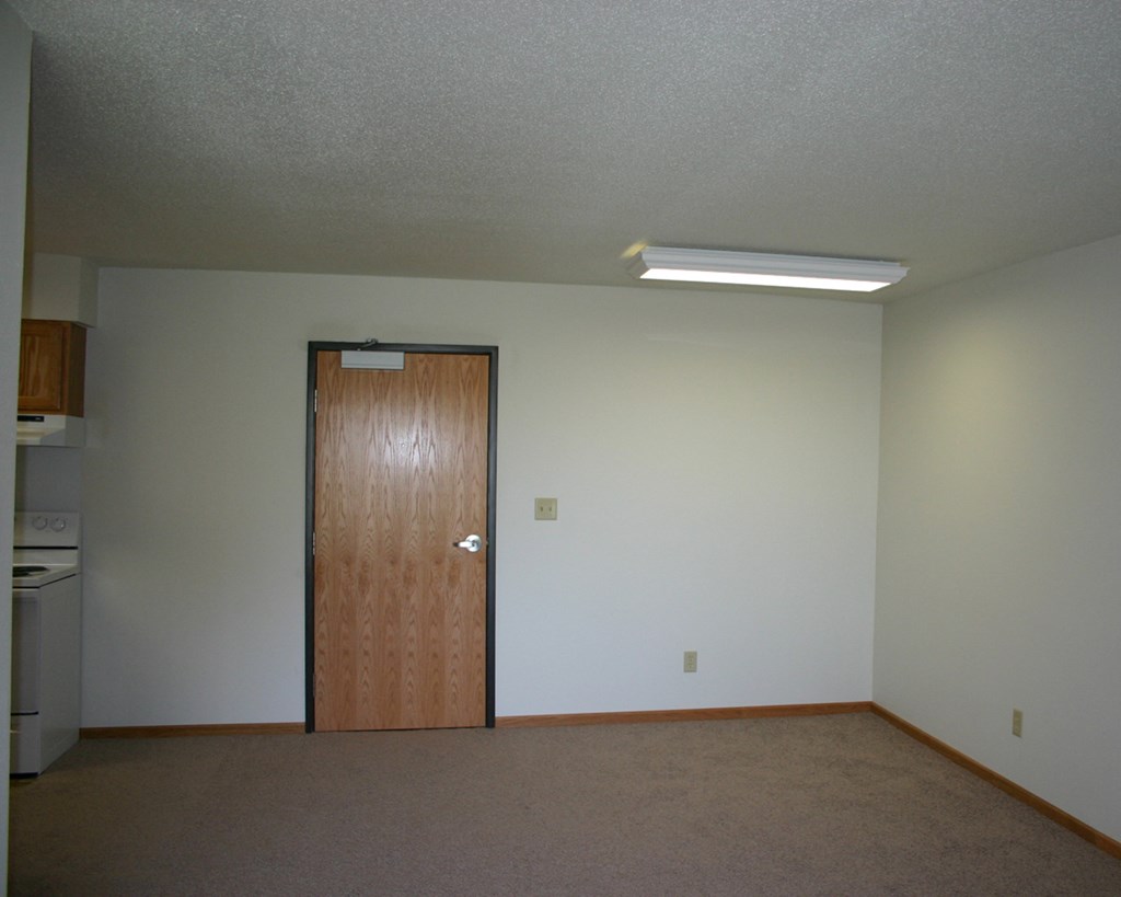 an empty room with a wooden door in it