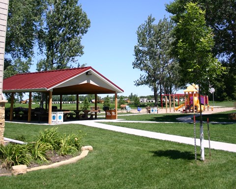 a pavilion in a park with a childrens play area