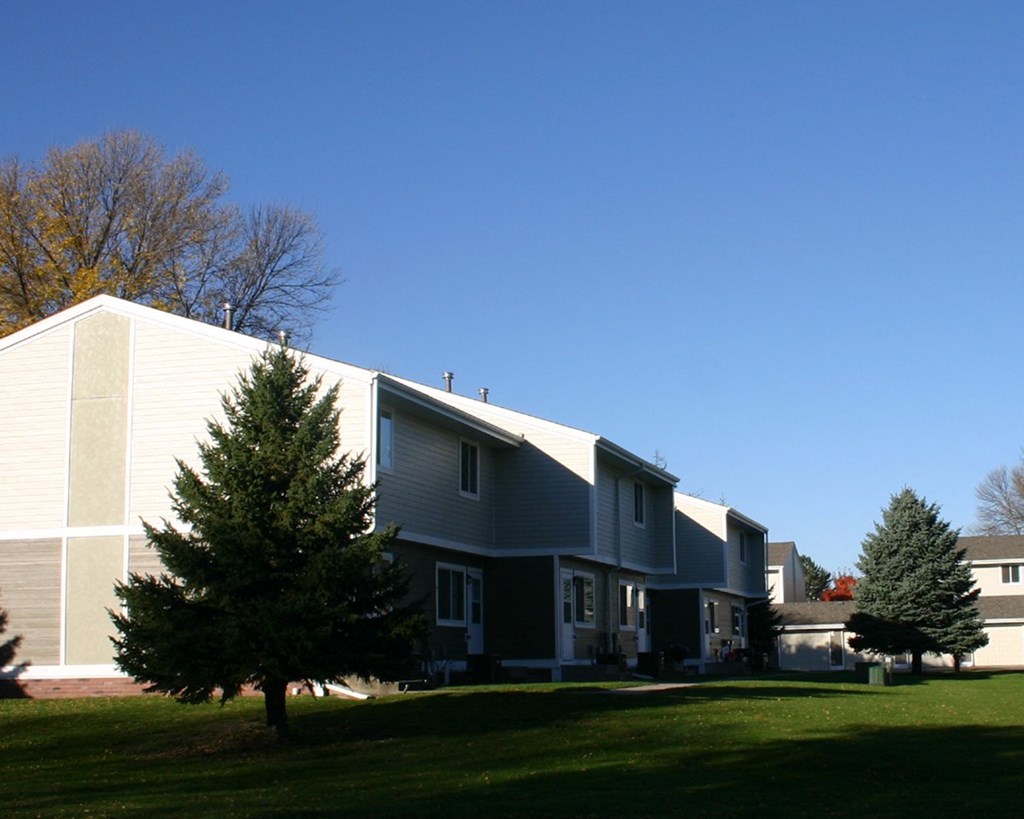 the side of a house with a yard in front of it