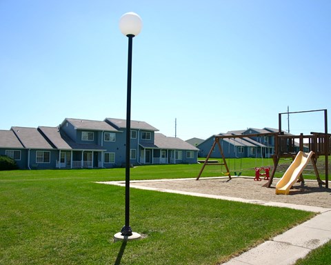a playground with a swing set and a light pole