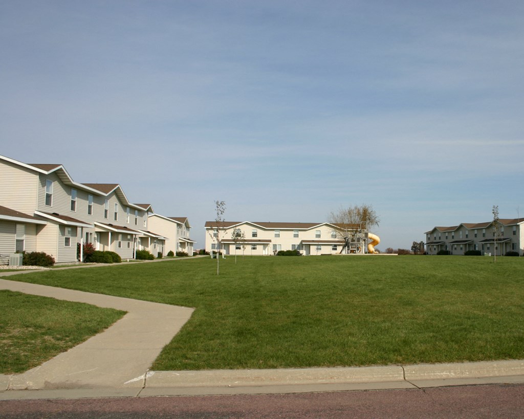 a row of houses on a lawn in a neighborhood