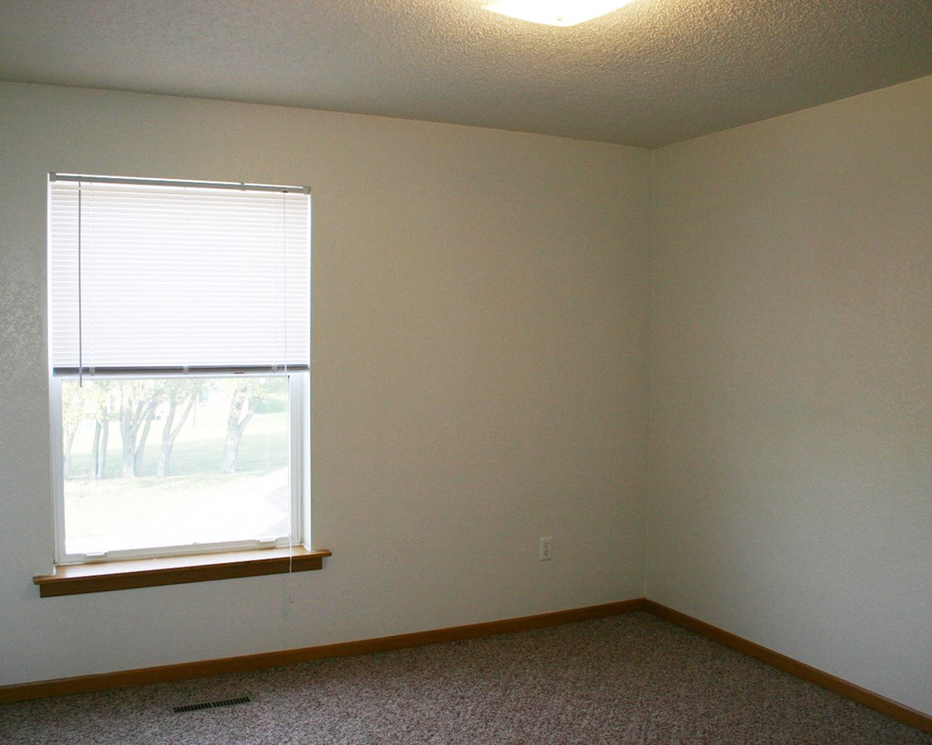 a room with a window and a carpet