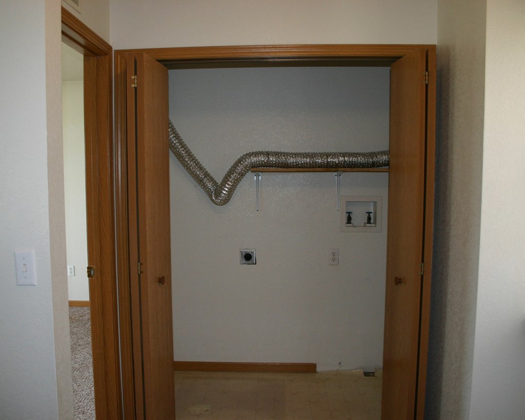 an open door to a room with a pipe in the wall