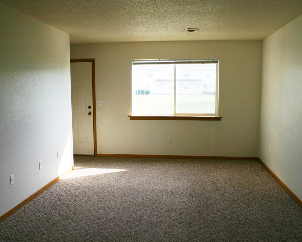 an empty room with a window and a door