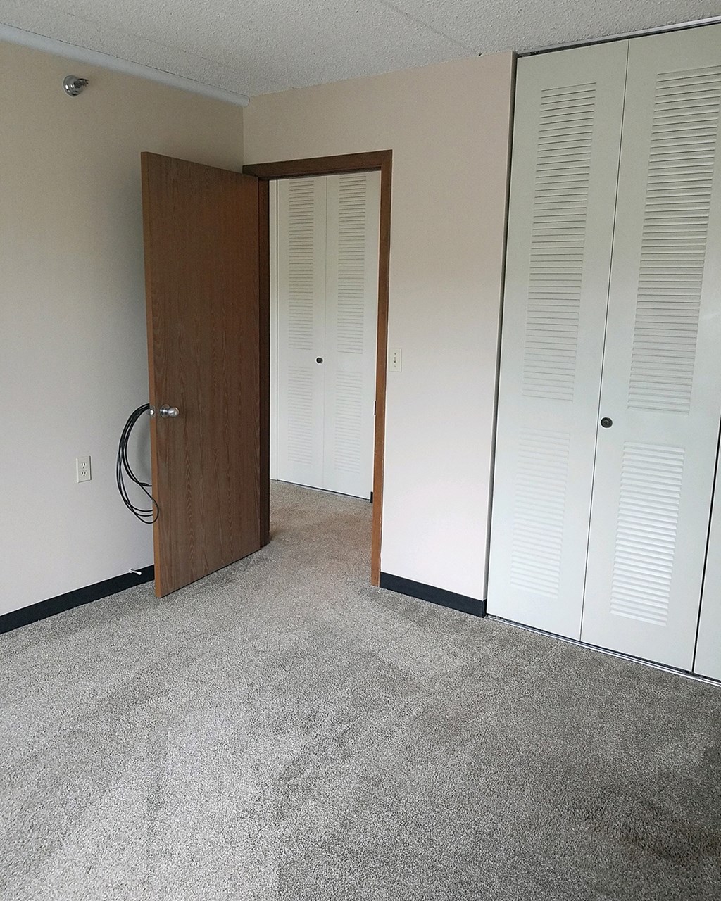 a room with a door to a closet and a carpeted floor
