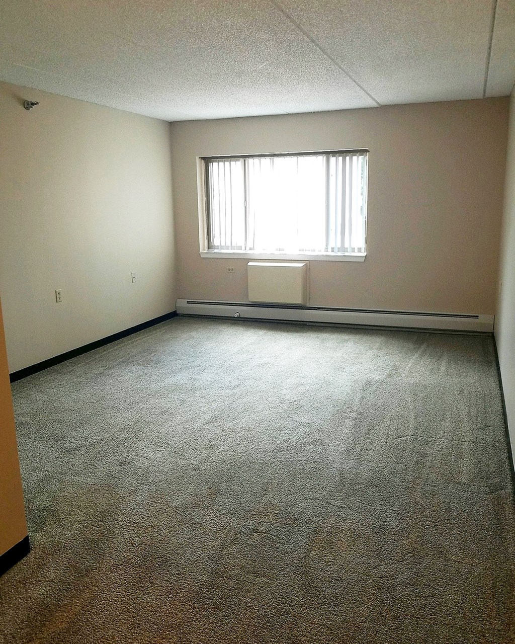 an empty room with carpet and a window