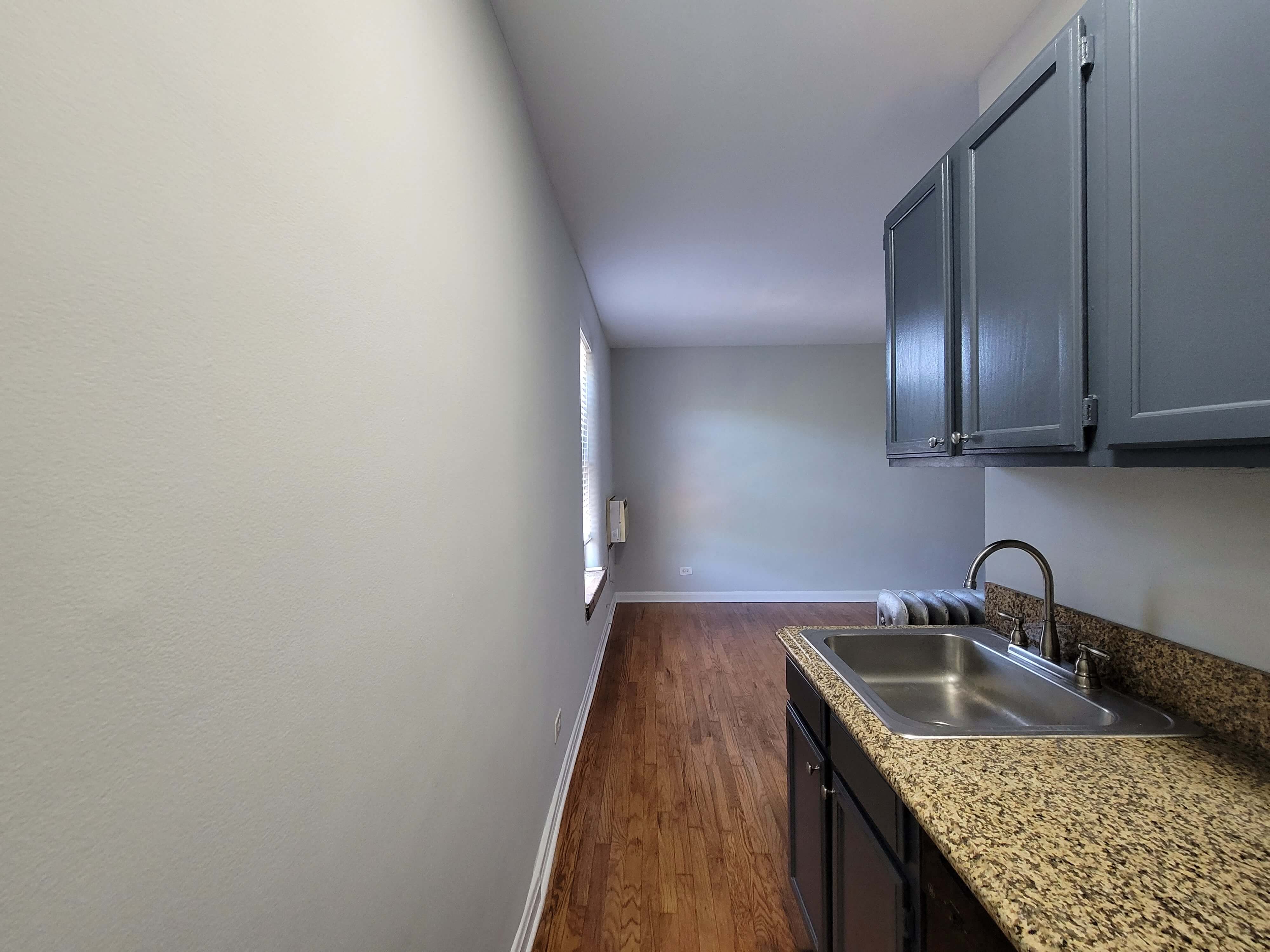 an empty kitchen with a sink and a counter top