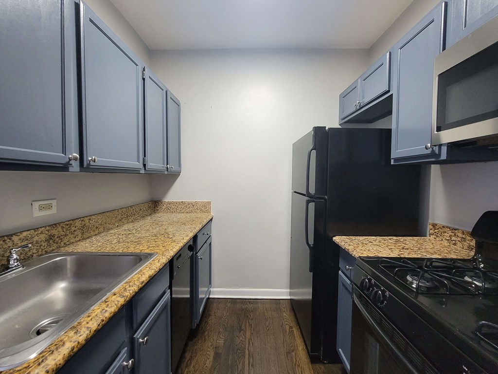 a kitchen with granite counter tops and black appliances