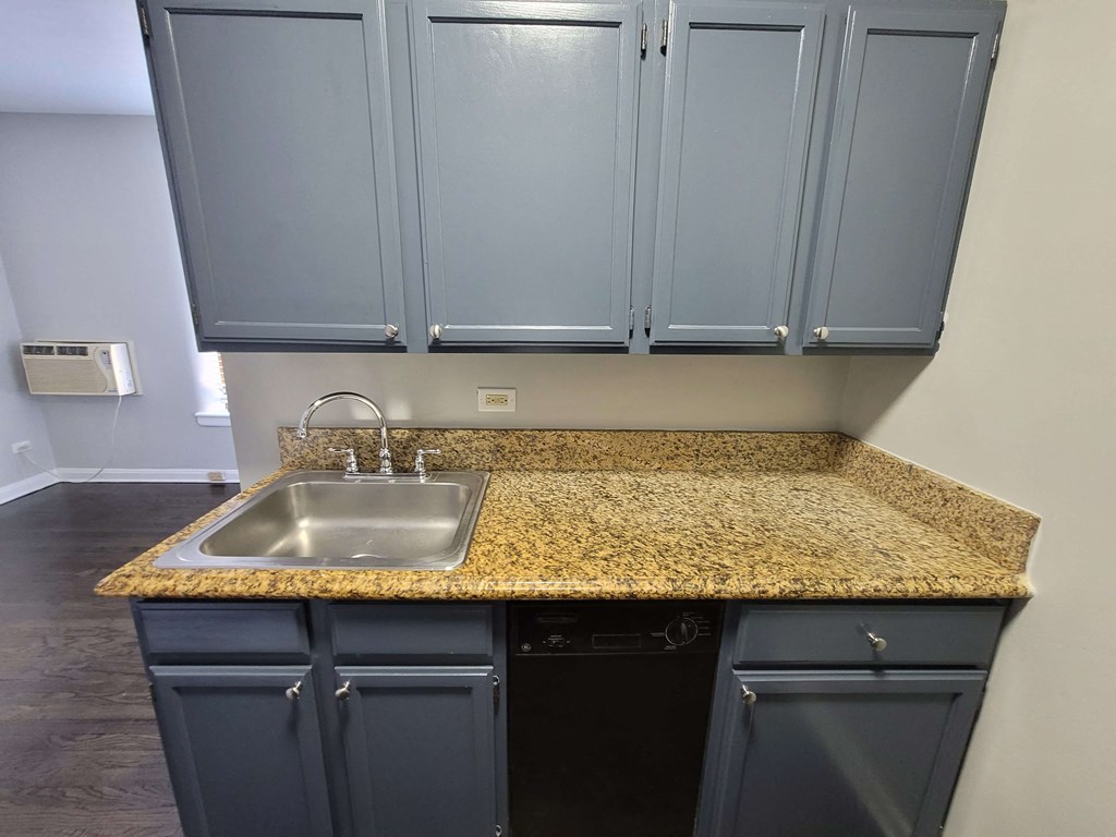 a kitchen with blue cabinets and a granite counter top and a sink