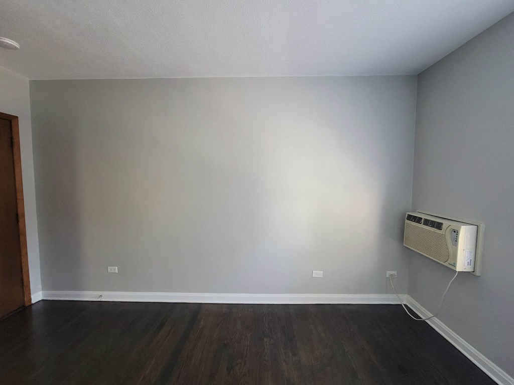 an empty room with a wall and a air conditioner
