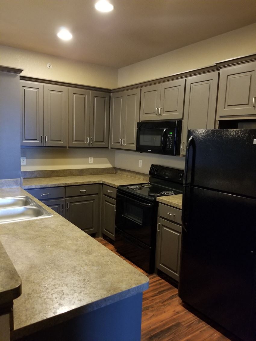 a kitchen with white cabinets and black appliances