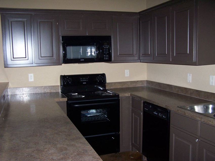 a kitchen with black appliances and black cabinets