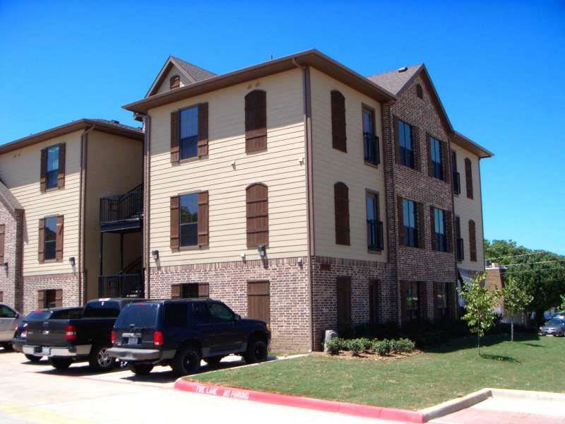 an apartment building with cars parked in front of it