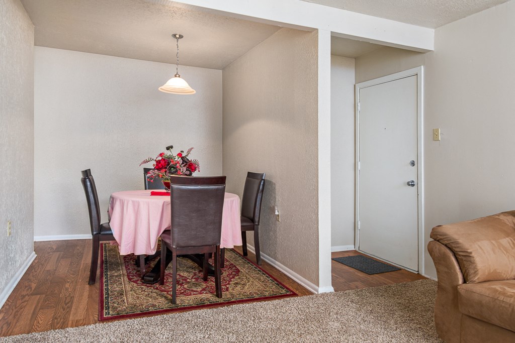 a dining room with a table with a pink table cloth and a couch
